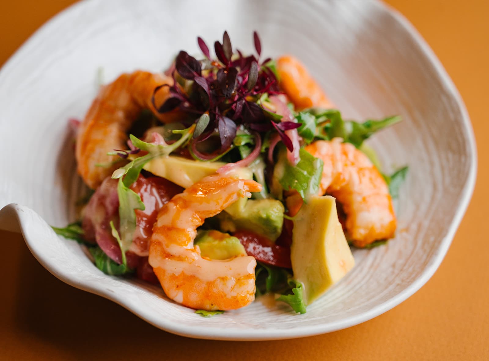 Салат с припущенными в белом вине креветками, авокадо, розовыми помидорами и соусом айоли-кимчи